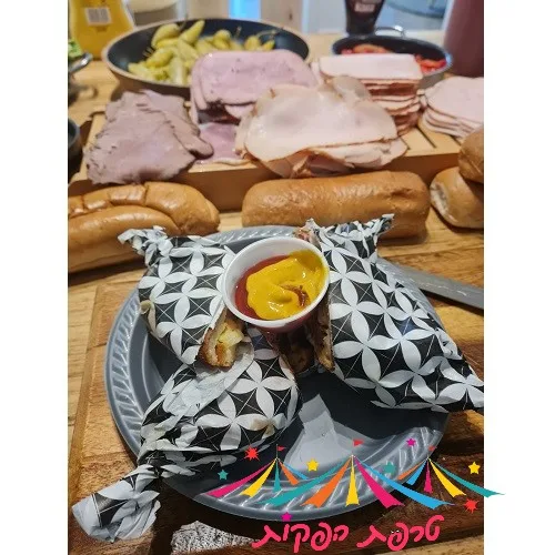 צוות טרפת אירועים מכין טוסט נקניק מושחת על פלנצ'ה לוהטת מול קהל אורחים
