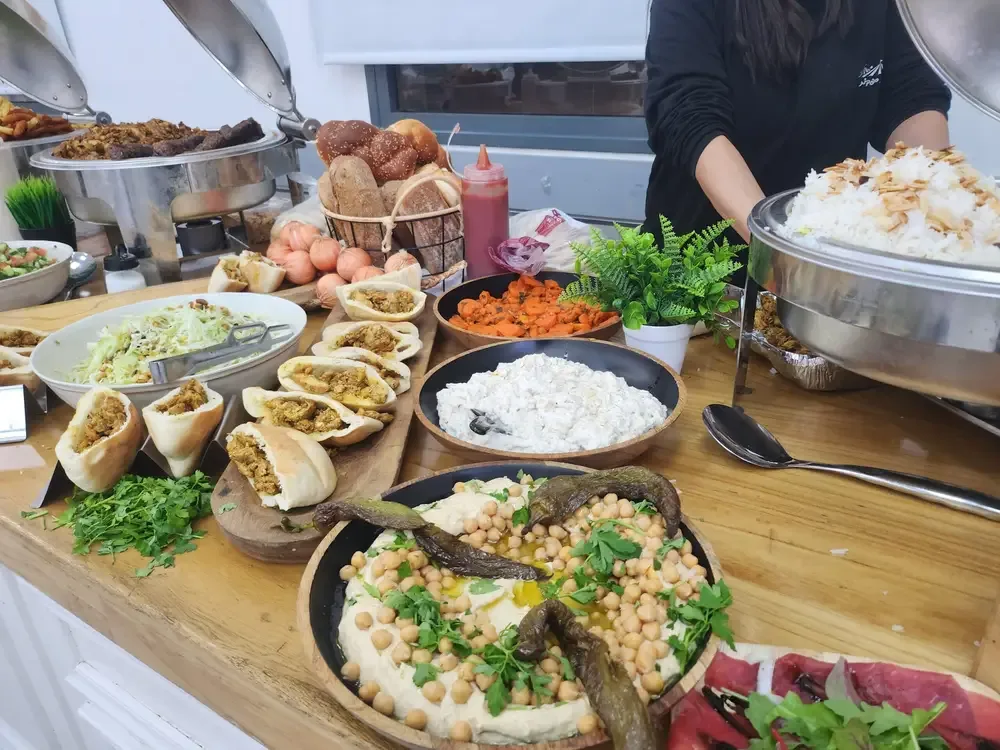 צוות גרילמנים מכין נתחי בשר בעמדת קייטרינג בשרים לאירועים של טרפת אירועים