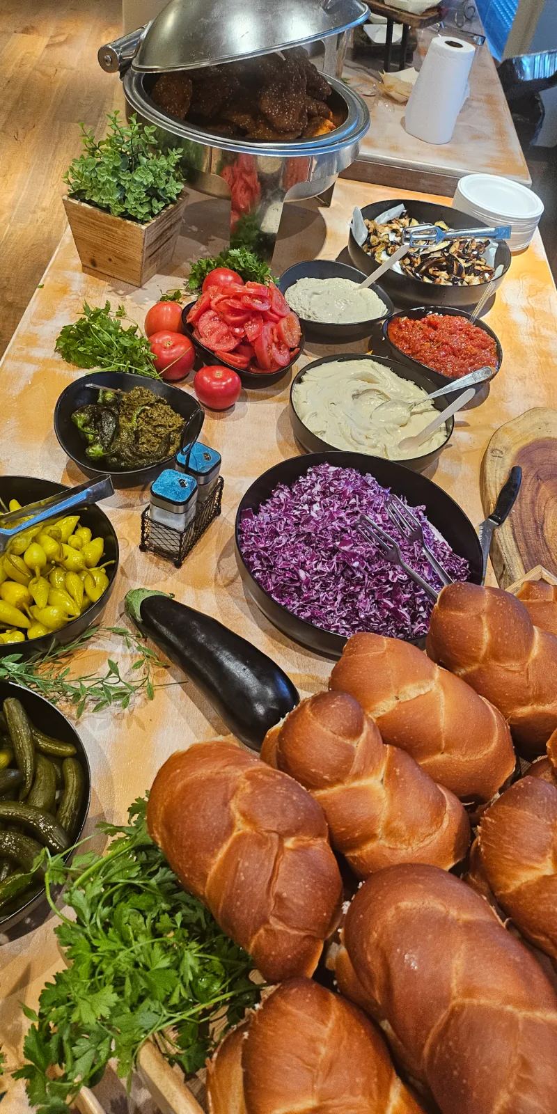 שניצל חם וקריספי בתוך החלה של שישי (שניצל) לצד סלטים צבעוניים באירוע בחדרה