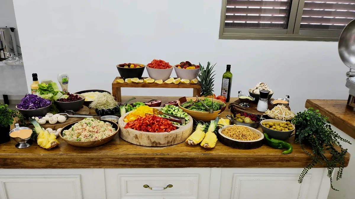 צוות טרפת אירועים מסדר את בר הסלטים הארטיזנלי לקראת החגיגה