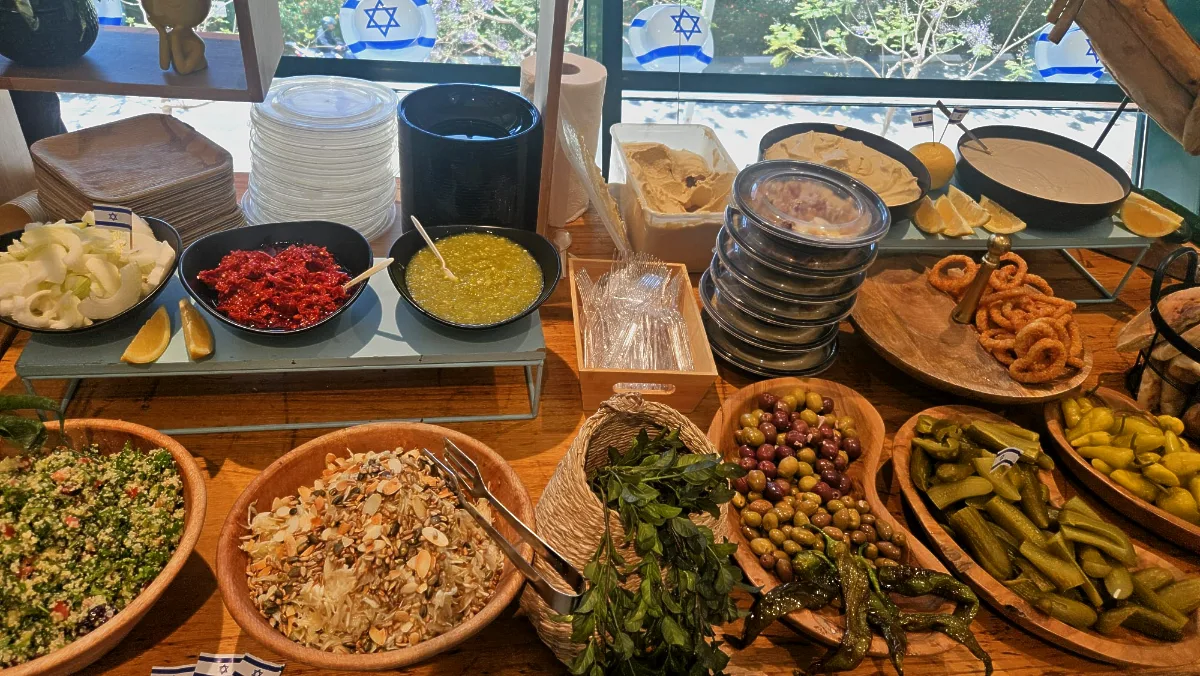 אורחים נהנים מניגוב חומוס אותנטי בעמדת זירת המנגבים