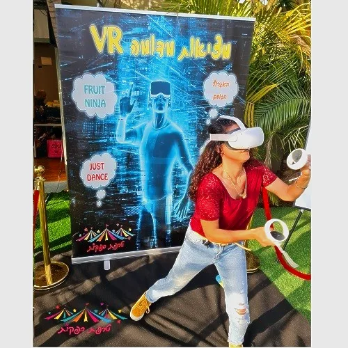 צוות טרפת אירועים מדגים שימוש בבקרים עם משקפי VR מול מסך ענק